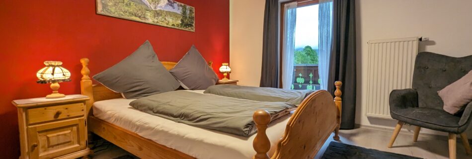 Helles Schlafzimmer im Süden des Ferienhauses Wiesenhof mit gemütlicher Einrichtung und Balkon