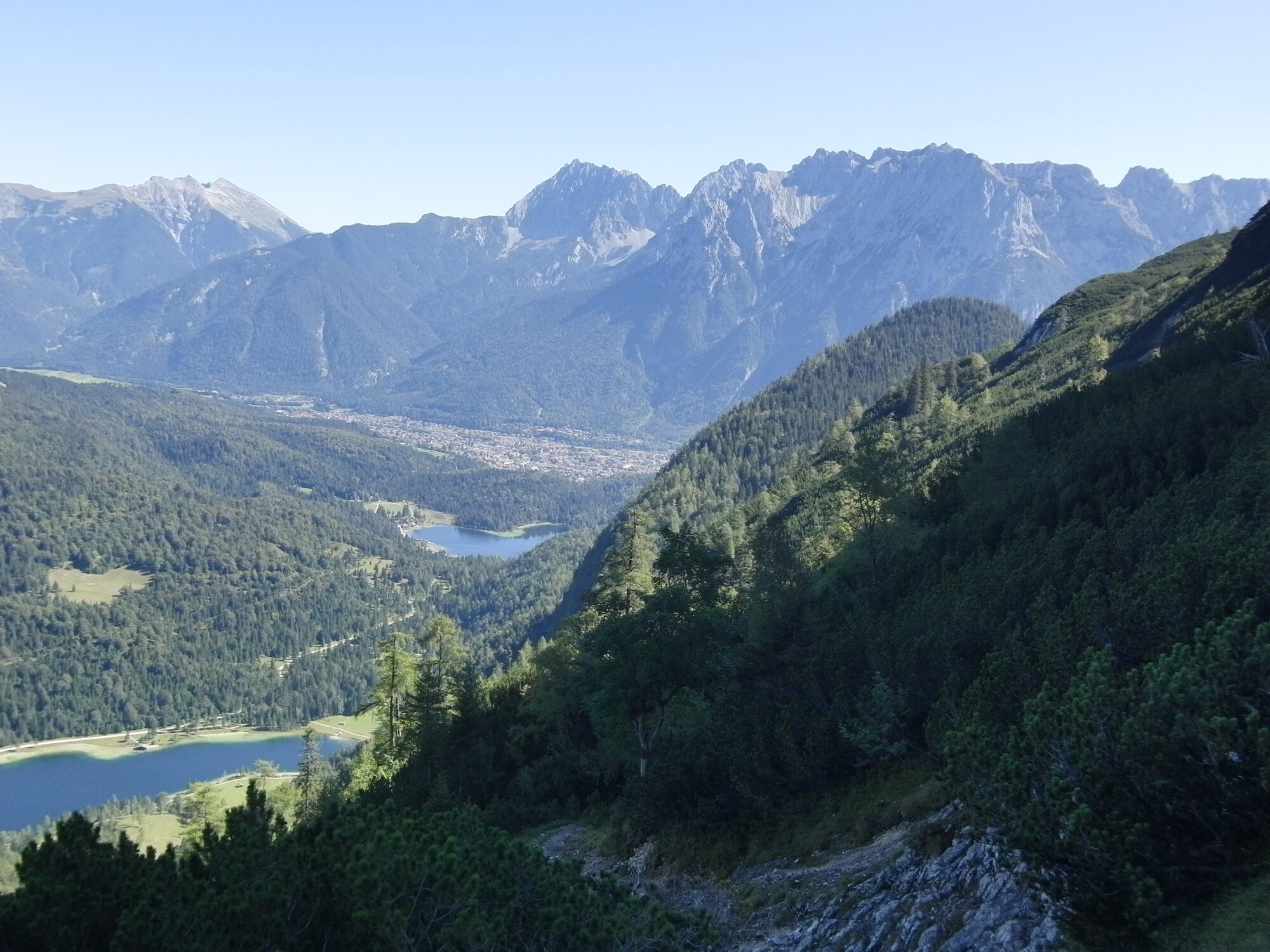Atemberaubender Blick vom Weg zum Wetterstein auf das Karwendelgebirge, Mittenwald und die malerischen Seen Lautersee und Ferchensee in der Nähe des Ferienhauses Der Wiesenhof in Klais.