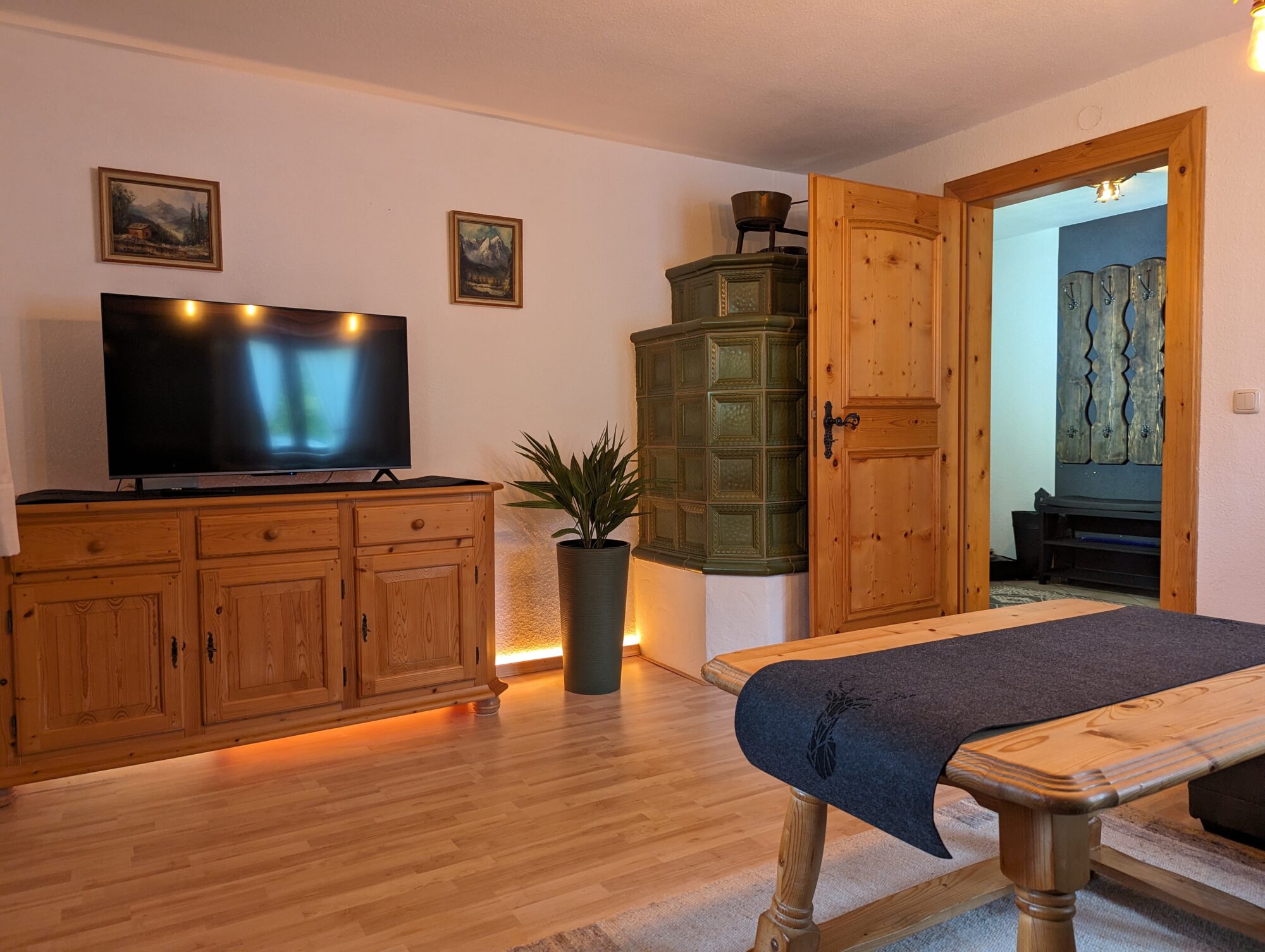 Wohnzimmer im Ferienhaus Wiesenhof in Klais mit traditionellem Holzofen und moderner Beleuchtung.