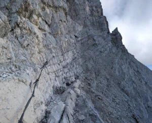 Felsiger Steig mit Drahtseilen an der steilen Wand zur Alpspitze