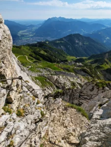 Blick vom Steig zur Alpspitze über das grüne Tal und die Berge im Hintergrund
