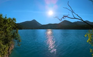 Sonnenreflexion auf dem Walchensee mit umliegenden Bergen