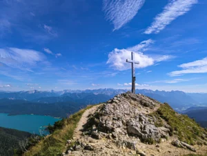 Gipfelkreuz am Heimgarten mit Blick über die Alpen und türkisfarbene Seen – Wandererlebnis vom Ferienhaus Wiesenhof in Klais.