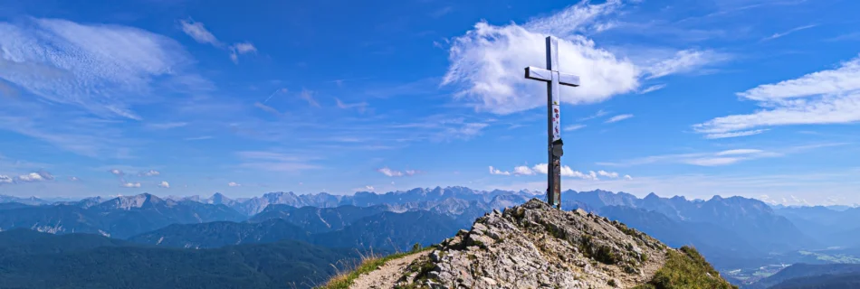 Gipfelkreuz am Heimgarten mit Blick über die Alpen und türkisfarbene Seen – Wandererlebnis vom Ferienhaus Wiesenhof in Klais.