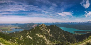 Panoramaaufnahme vom Heimgarten über Berge, Täler und Seen – Herzogstand eingerahmt von Kachelsee und Walchensee Urlaub im Ferienhaus Wiesenhof Klais.