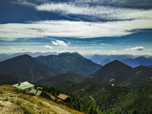 Berghütten unterhalb des Heimgarten-Gipfels mit Blick auf die Alpenkette – Erlebniswanderung ab Ferienhaus Wiesenhof Klais.