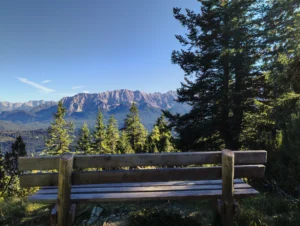 Holzbank beim Aufstieg auf den Wank mit Blick auf das Wettersteingebirge, Wandern in Oberbayern nahe dem Ferienhaus Wiesenhof Klais.